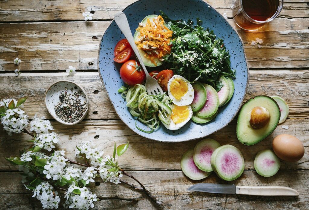 prato de salada com abacate, cenouro e folhas verdes