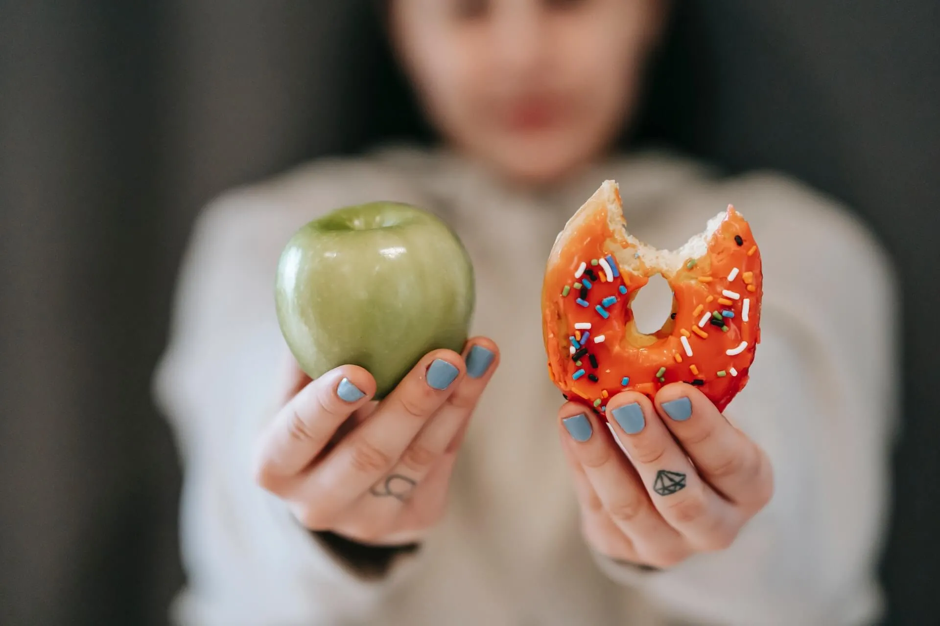 mulher segurando uma maça e um donut