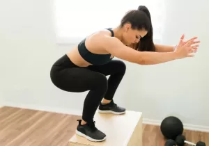 mulher fazendo agachamento em uma plataforma