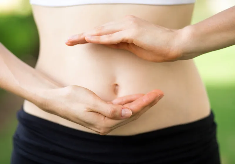 close up de mãos da mulher na barriga 