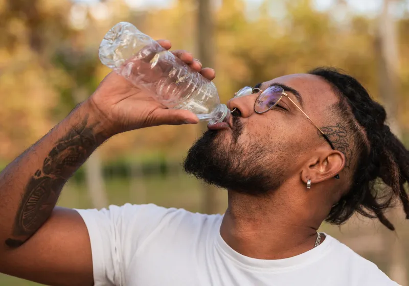 vista lateral de homem negro bebendo água 