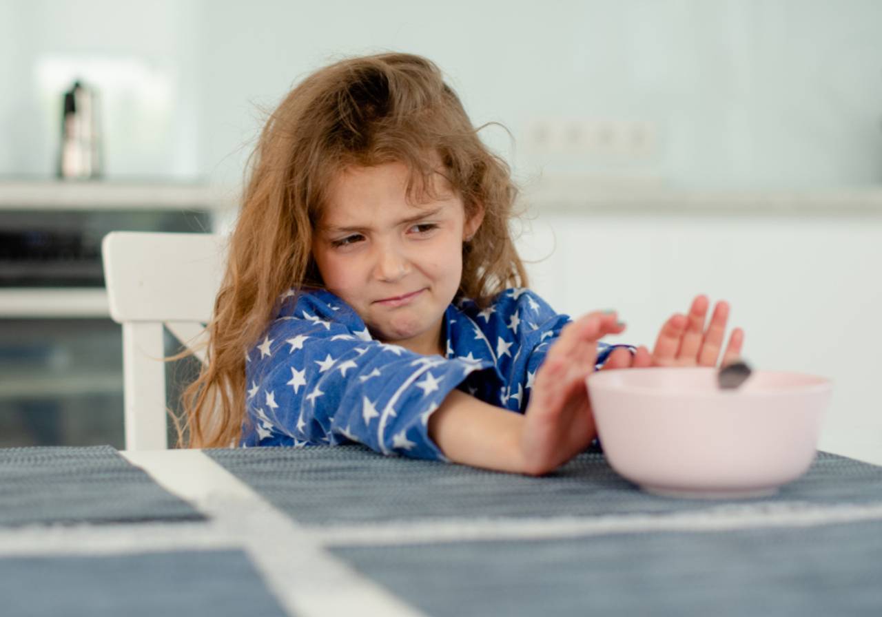 criança negando pote de comida