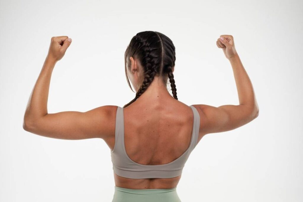 mulher mostrando as costas com os braços abertos