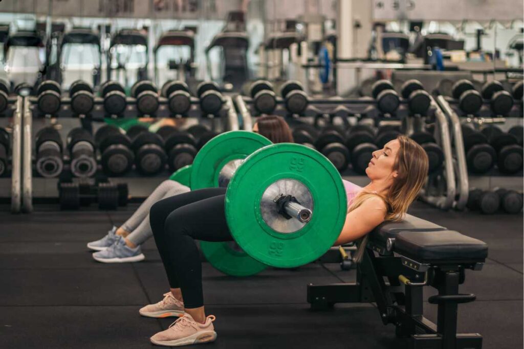 mulher fazendo levantamento com peso na academia