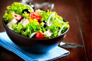 Balde de salada com alface, tomate, cebola, azeitonas pretas e tofu em cubos