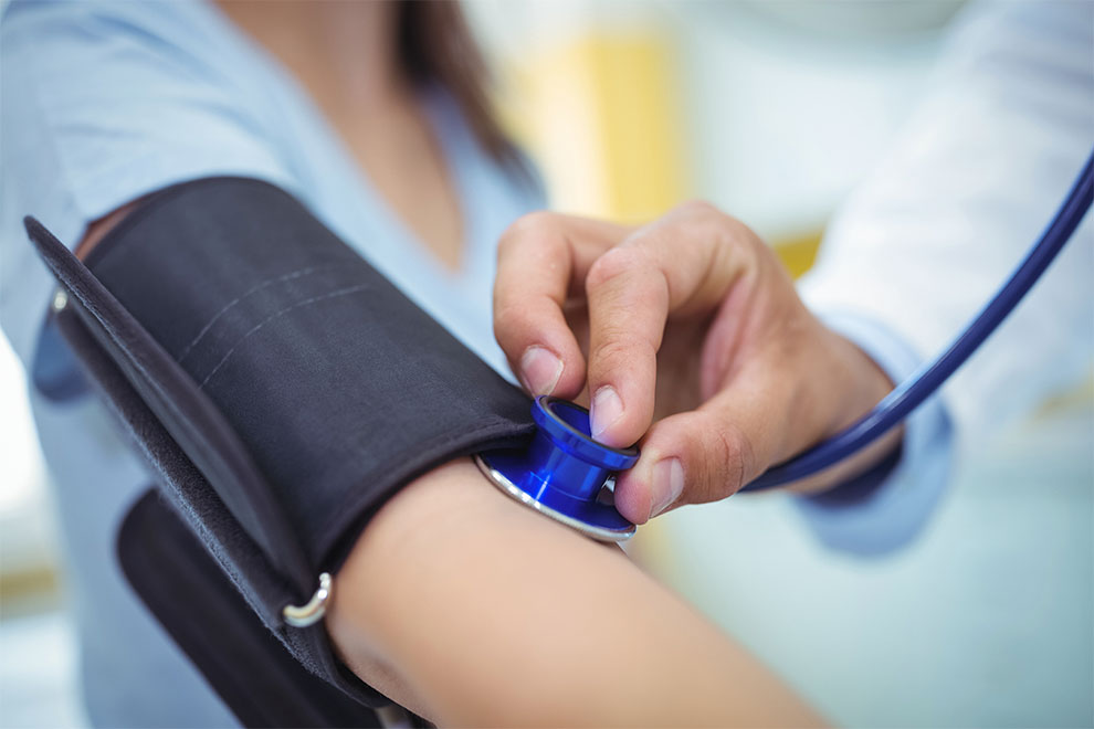 uma pessoa checando sua pressão arterial com um médico