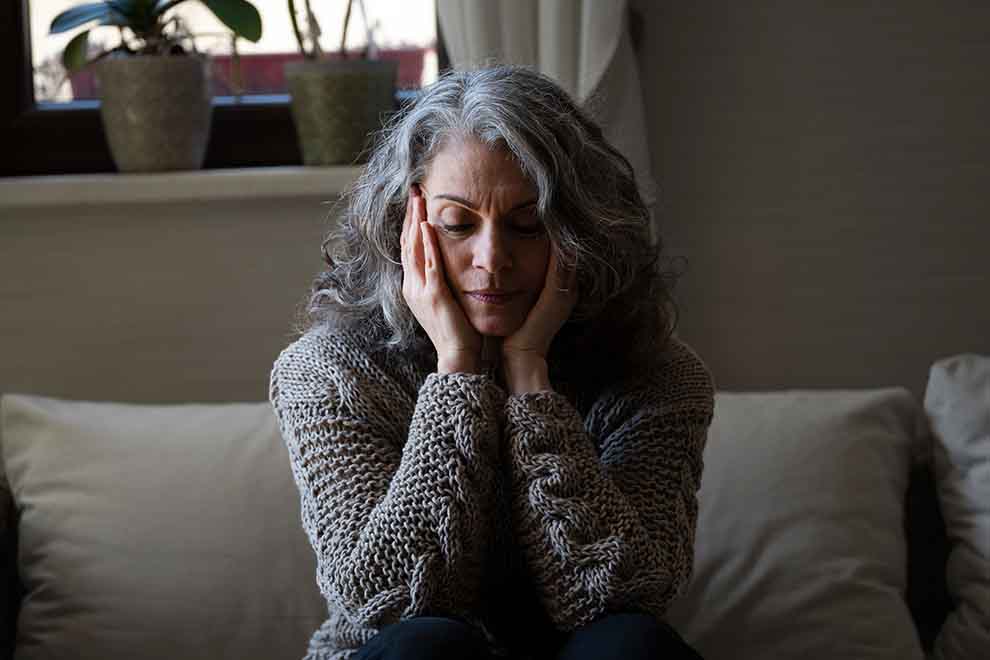 ansiedade e estresse Mulher com cabelo grisalho pensativa em sofá